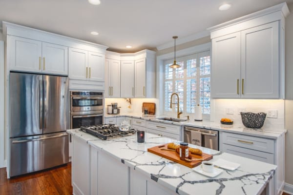 Quartz countertop installation in a Cincinnati kitchen completed by Tranquil Kitchen & Bath, featuring an undermount sink and clean tile backsplash.